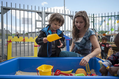 Child playing in a sand pit as part of our additional needs support